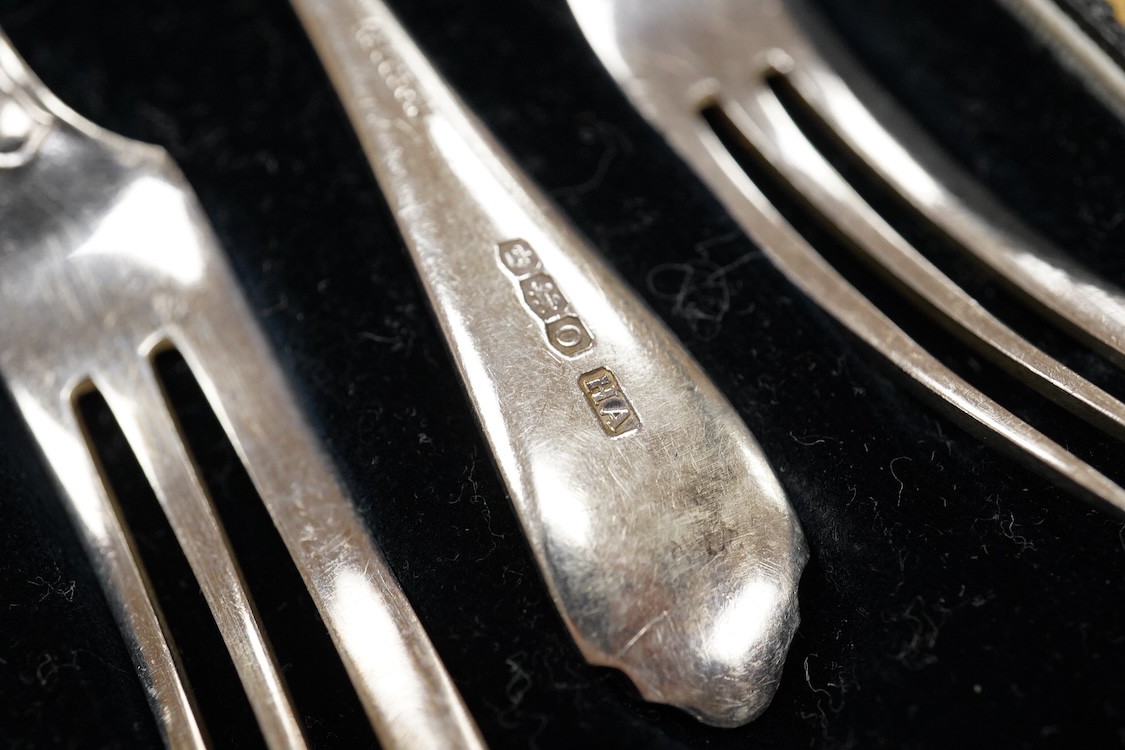 A cased set of six George V silver pastry forks, by Atkin Brothers, Sheffield, 1931, together with a cased set of six Edwardian silver apostle teaspoons and pair of sugar tongs, by Charles Stuart Harris & Sons, London, 1